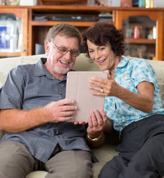 IRT home care staff member assisting older man with technology in his home