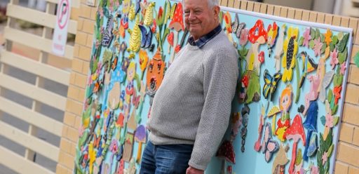 Our residents embrace creativity and an example is IRT Macarthur pottery teacher Michael Bright. He is standing in front of the community’s pottery wall.