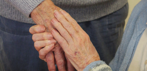 Supportive hands comforting an elderly person